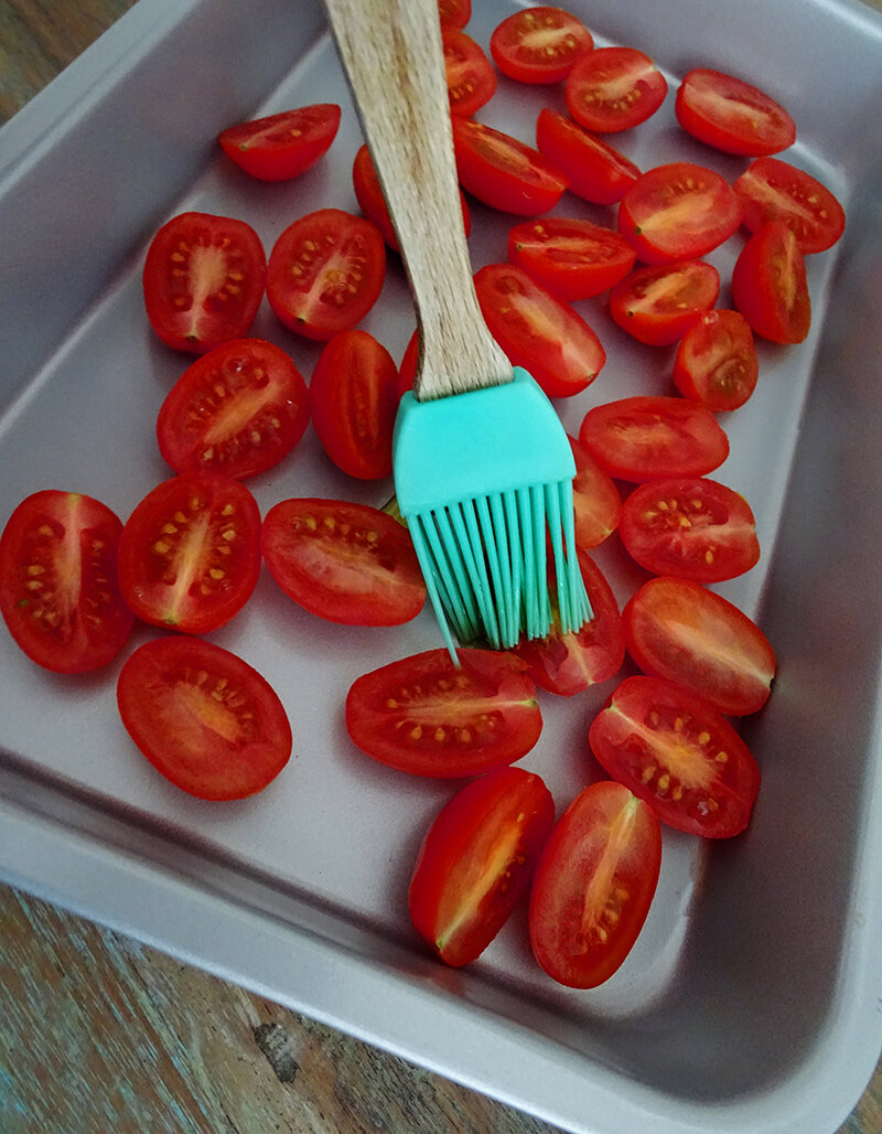 The tomatoes are cut in half and brushed with oil